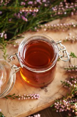 Cam kavanozda bitkisel şurup ve ormanda toplanan taze yabani kenevir çiçekleri.