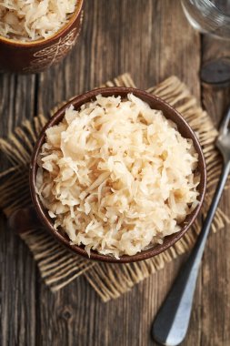 Ev yapımı mayalanmış lahana ya da lahana turşusu, ahşap bir masada, üst tarafta.