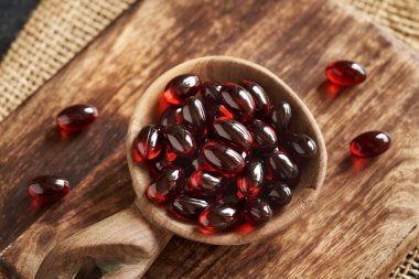 Bir kaşıkta kril yağı kapsülleri. Omega-3 yağ asitleri açısından zengin besin takviyesi.