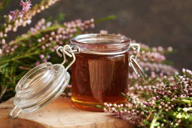 Cam bir kavanozda bitkisel şurup ve sonbaharda ormanda toplanan taze yabani kenevir çiçekleri.