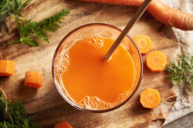 Bir bardak geri dönüşümlü kağıt kamışlı taze havuç suyu. Sıfır atık.