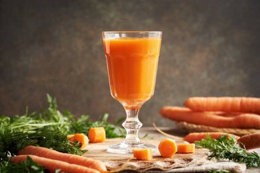 İçerideki ahşap masada taze havuç suyu.