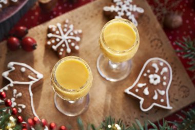 Beyaz kremayla süslenmiş ev yapımı zencefilli Noel kurabiyeleriyle iki bardak Eiecognac.