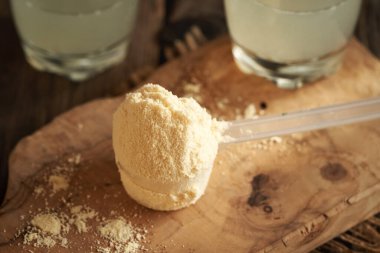 Bir ölçü kaşığında beyaz protein tozu, yakın plan.