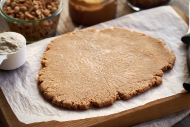 Rolled out dough made of whey protein powder, maple syrup and peanut butter - making homemade no-bake protein bars clipart