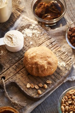 Sütlü protein tozu, akçaağaç pekmezi ve fıstık ezmesinden yapılmış hamur topu. Ev yapımı, fırınlanmamış protein çikolatalarının malzemesi.