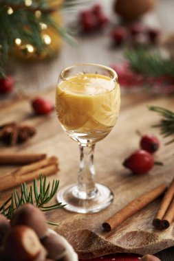Tarçınlı bir bardak Eierkonyak ve Noel süslemesi.