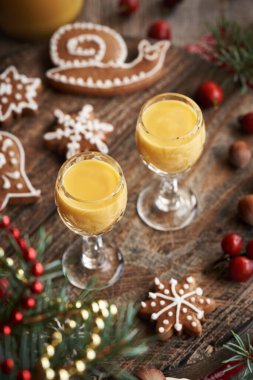 İki kadeh Eiecognac, yanında Noel kurabiyesi ve masa süslemesi.