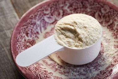 Beyaz plastik kepçe içinde beyaz protein tozu