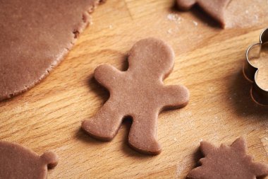 Man shape cut out from raw pastry dough - preparation of homemade gingerbread Christmas cookies clipart