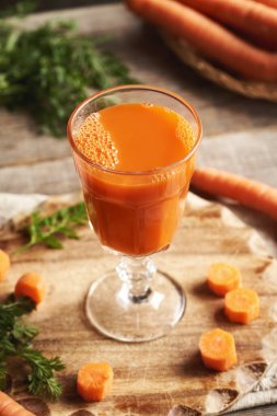 Tahta masada bir bardak taze havuç suyu.