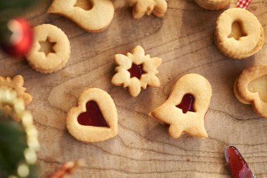 Çan, yıldız ve kalp şeklinde ev yapımı Linzer Noel kurabiyeleri çilekli marmelatla dolu.