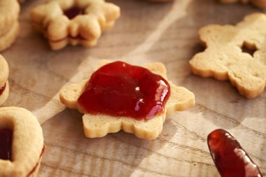 Geleneksel Linzer Noel kurabiyelerini kırmızı çilek reçeli ile doldurmak.