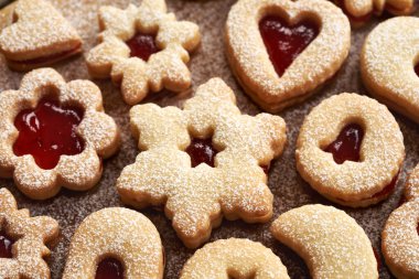 Kırmızı çilek reçeliyle doldurulmuş ev yapımı Linzer Noel kurabiyeleri.