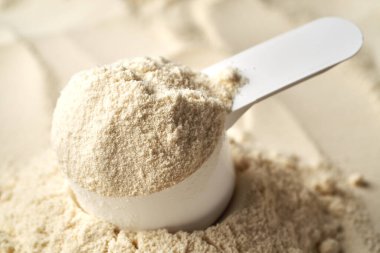 Bir ölçü kepçesinde beyaz protein tozu, yakın plan