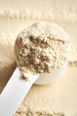 Beyaz plastik kepçe içinde beyaz protein tozu