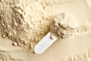 Bir ölçü kabında beyaz protein tozu, üst görünüm