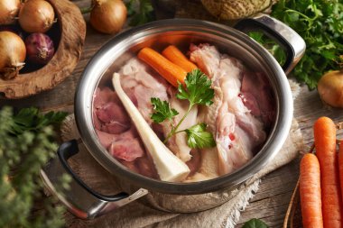 Çiğ tavuk eti, ciğer ve taze sebzeler bir tencere suda - ev yapımı kemik suyu veya çorba için gerekli malzemeler