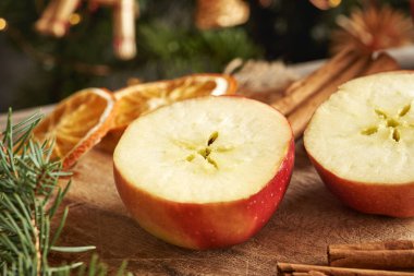 Ortasında bir yıldız olan yarım elma, tarçın, çam ağacı dalları ve Noel süslemeleri.