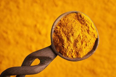 Bir tahta kaşık üzerinde zerdeçal tozu