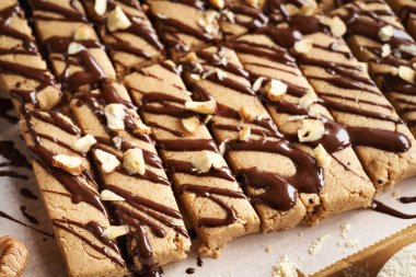 Sütlü protein tozu, yulaf ezmesi, akçaağaç şurubu, tarçın ve fındık ezmesi ile yapılan ev yapımı atıştırmalık barlar.