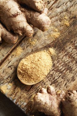 Zemin zencefil tozu ve ahşap bir masada taze zencefil kökü.