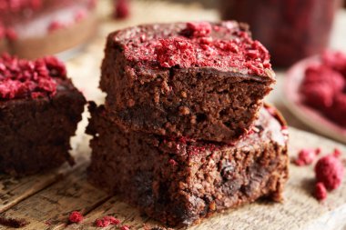 Bir yığın ev yapımı glütensiz browni kırmızı böbrek fasulyesi, yulaf gevreği, çikolata ve dondurulmuş ahududu.