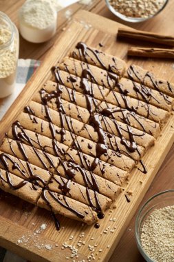 Süt tozu, yulaf gevreği, susam tahini, akçaağaç şurubu ve tarçından yapılmış ev yapımı sağlıklı barlar.