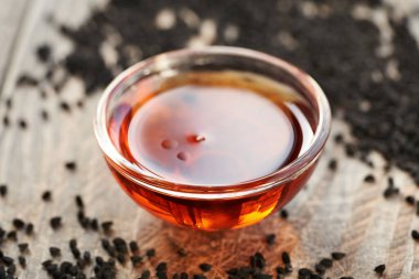 Bir kase siyah kimyon ya da Nigella sativa tohumu yağı. Sağlıklı besin desteği.