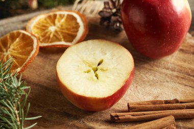 Ortasında yıldız şekli olan yarı kırmızı elma, tarçın ve Noel süslemesi.