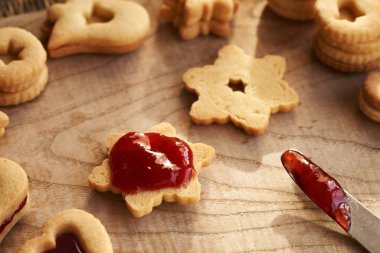 Yıldız şeklinde Linzer Noel kurabiyesi çilek reçeli ile dolduruluyor