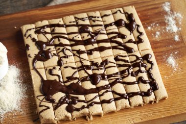 Süt tozu, yulaf ezmesi, akçaağaç pekmezi ve çikolata ile süslenmiş fındık ezmesinden yapılmış ev yapımı atıştırmalıklar.