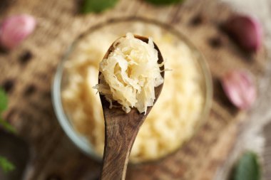 Tahta bir kaşığın üstünde mayalanmış lahana ya da lahana turşusu