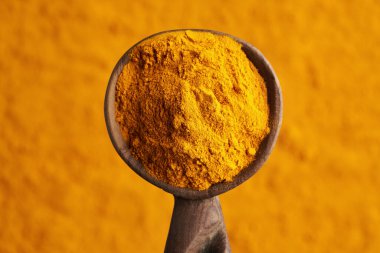 Tahta kaşıkta zerdeçal kökü tozu, üst manzara.