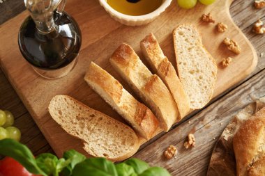 Bir şişe balzamik sirke, zeytinyağı, üzüm ve ceviz dilimlenmiş İtalyan ciabatta ekmeği.