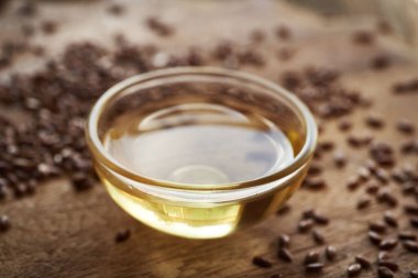 Keten tohumu yağı cam kasede keten tohumlarıyla dolu bir masada.