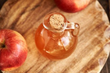 Elma şarabı sirkesi. Tahta bir masada cam sürahi içinde.