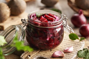 Cam kavanozda fermente pancar kvass hazırlamak için taze pancar, soğan, sarımsak ve baharat.