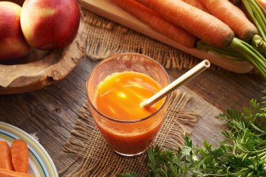 Cam bardakta taze havuç suyu ve geri dönüşümlü bambu kamışı.