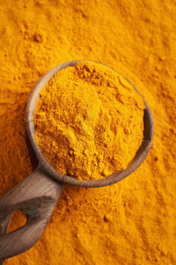 Bir tahta kaşık üzerinde zerdeçal tozu
