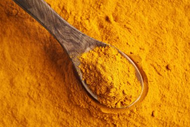 Tahta kaşıkta zerdeçal kökü tozu, yakın plan.