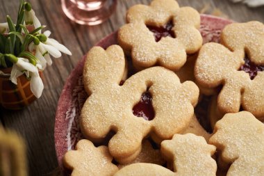 Ev yapımı Linzer kurabiyesi. Kırmızı tabakta Paskalya hayvanları şeklinde. Yakın plan.