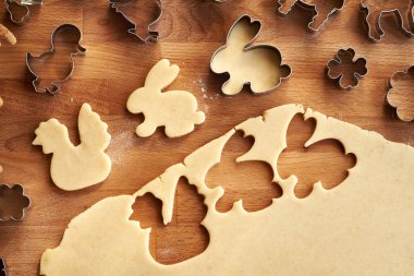 Tavşan ve tavuk şekilleri hamur hamurundan kesilir. Ev yapımı Linzer Paskalya kurabiyeleri, üst manzara.