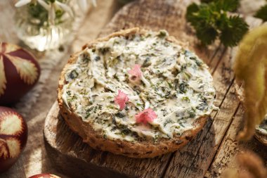 Baharda yenebilir yabani akciğer otu çiçekleri ve ısırgan otu yağıyla bir dilim ekmek.