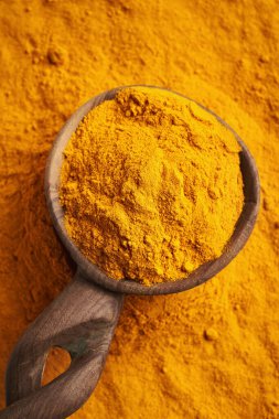 Tahta kaşıkta zerdeçal kökü tozu, üst manzara.