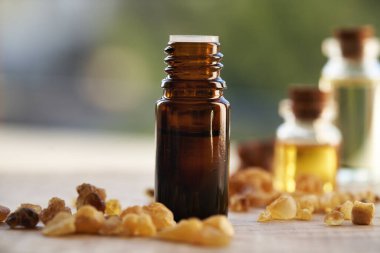 Açık havada tütsü kristalleriyle tütsülenmiş koyu bir tütsü şişesi.