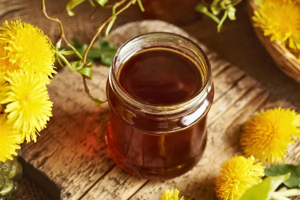 Taze karahindiba çiçekli cam bir karahindiba kavanozu.