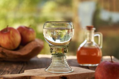 Bir bardak su ve açık bir masada biraz elma sirkesi.