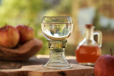 Açık havada elma sirkeli cam bir bardak su.