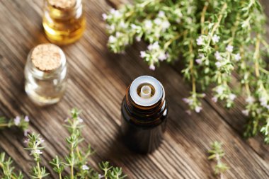 Kahverengi bir aromaterapi şişesi çiçek açan kekik yağı.